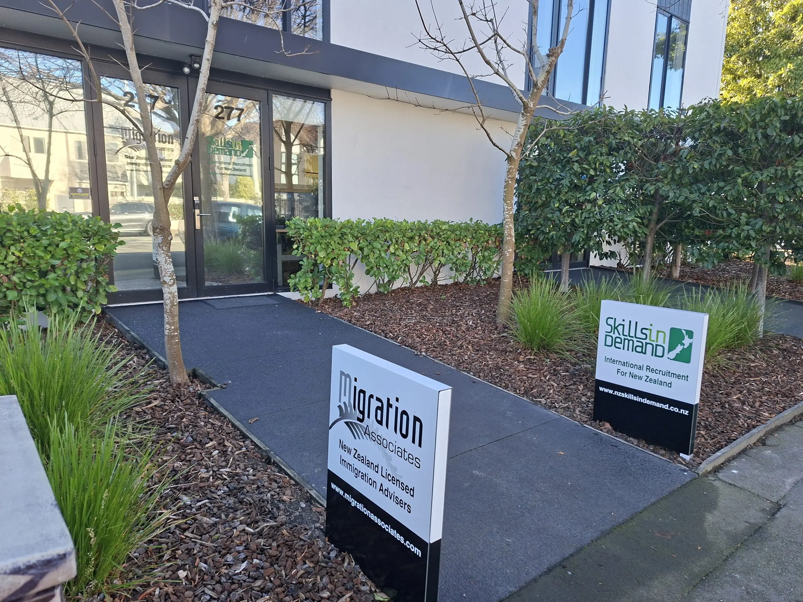20260811_112208 Photo of Migration Associates entrance with street signage and door signage. New Zealand immigration advisor